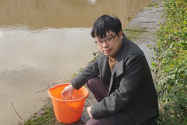 Nicholas testing for river pollution. Nicholas collecting water sampling